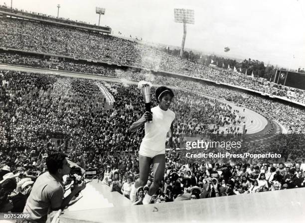 Mexican athlete Enriqueta Basilio runs up the steps towards the Olympic Torch to light the Olympic Flame during the 1968 Summer Olympics opening...