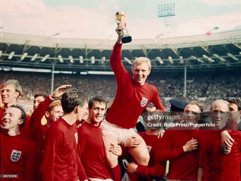 Sport Football. pic: 30th July 1966. 1966 World Cup Final at Wembley. England 4 v West Germany 2 a.e.t. England captain Bobby Moore holds aloft the World Cup (Jules Rimet trophy) as the team gather around to celebrate.