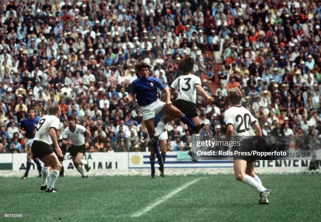 1970 World Cup Semi-Final, Mexico City, Mexico 17th June, 1970. Italy 4 v West Germany 3. West German player Gerd Muller jumps for the ball with an Italian defender as teammates Uwe Seeler (9) and Jurgen Grabowski (20) look on during the two teams' semi-