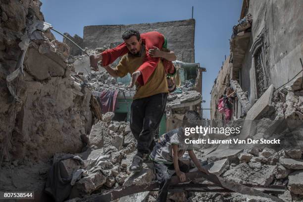 Men, women and children emerge from the rubble of al-Nuri mosque complex on June 29 in Mosul, Iraq. The Iraqi Army, Special Operations Forces and...