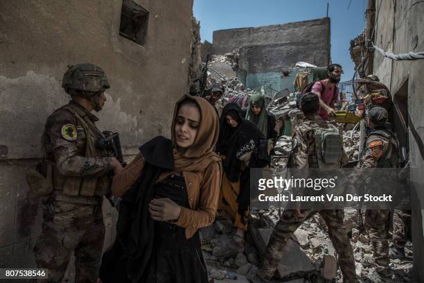 Men, women and children emerge from the rubble of al-Nuri mosque complex on June 29 in Mosul, Iraq. The Iraqi Army, Special Operations Forces and...
