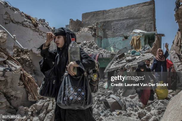 Women and children emerge from the rubble of al-Nuri mosque complex on June 29 in Mosul, Iraq. The Iraqi Army, Special Operations Forces and...