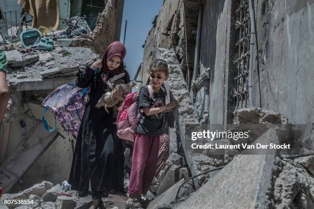 Women and children emerge from the rubble of al-Nuri mosque complex on June 29 in Mosul, Iraq. The Iraqi Army, Special Operations Forces and...