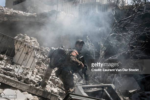 An Iraqi commando advances through the dust and rubble of al-Nuri mosque complex in Mosque complex on June 29, 2017 in Mosul, Iraq. The Iraqi Army,...