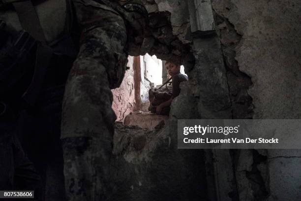 Boy sits amid destroyed buildings in al-Nuri mosque complex on June 29 in Mosul, Iraq. The Iraqi Army, Special Operations Forces and...