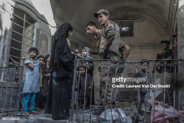 Iraqi soldiers speak to a family they discovered in al-Nuri mosque complex on June 29 in Mosul, Iraq. The Iraqi Army, Special Operations Forces and...