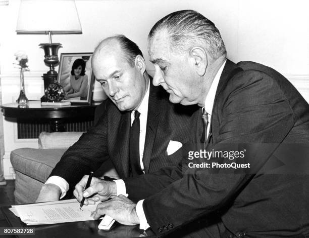 Watched by Attorney General Nicholas Katzenbach , US President Lyndon B Johnson signs a transmittal letter to accompany the Voting Rights Bill,...