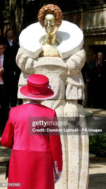 Britain's Queen Elizabeth II, looks at a statue of Queen Elizabeth I, by sculptor Matthew Spender, during a visit to Westminster Abbey and...