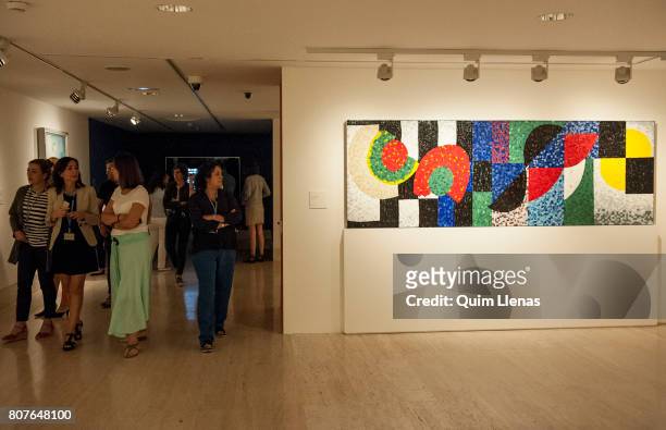Some visitors walk past the 'Mosaico horizontal' during the press preview of the exhibition 'Sonia Delaunay. Art, Design and Fashion' at...
