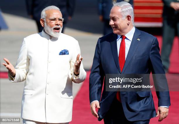 Israeli Prime Minister Benjamin Netanyahu walks with his Indian counterpart Narendra Modi during an official ceremoney at Ben-Gurion International...