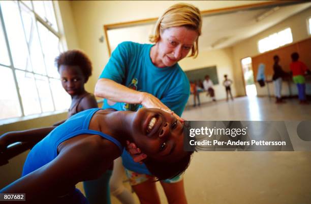 Nadia Krylova, a former soloist at the Bolshoi Ballet in Moscow, instructs Aknona Magnina during a ballet class at Yomelela school May 24, 2000 in...