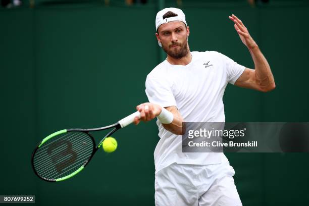 Daniel Brands of Germany plays a forehand during the Gentlemen's Singles first round match against Gael Monfils of France on day two of the Wimbledon...