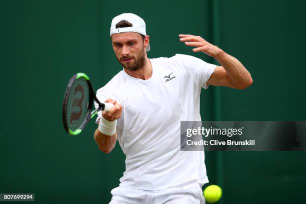 Daniel Brands of Germany plays a forehand during the Gentlemen's Singles first round match against Gael Monfils of France on day two of the Wimbledon...