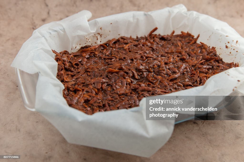 Oven dish with baking paper and brownie of sweet potato batter.