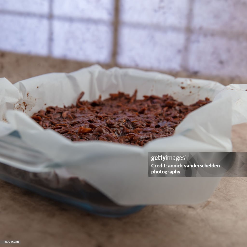 Oven dish with baking paper and brownie of sweet potato batter.