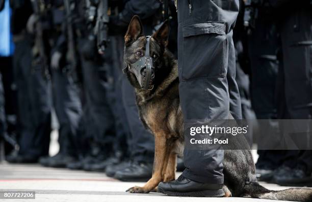 Police dog stands with its handler during a visit by German Interior Minister Thomas de Maiziere to a special federal police unit at the fair halls...