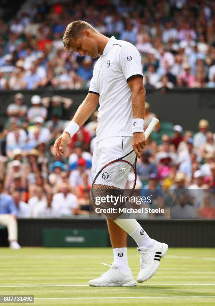 Martin Klizan of Slovakia reacts to picking up a injury that causes him to retire during the Gentlemen's Singles first round match again Novak...