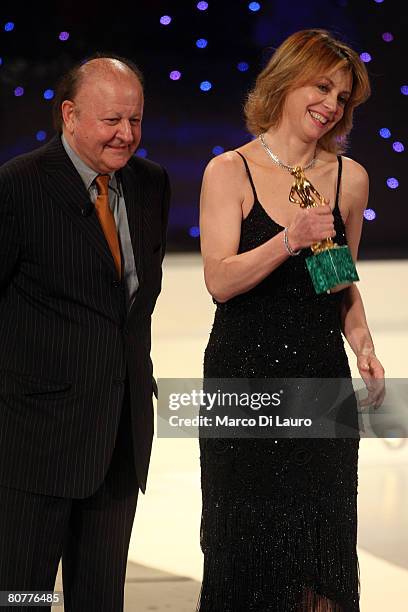 Italian actress Margherita Buy holds the David di Donatello statuette received from Italian actor Massimo Boldi after being awarded best actress for...