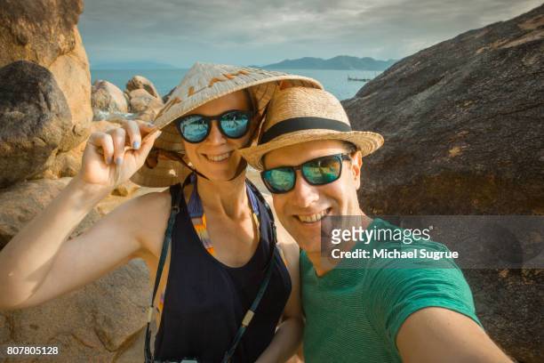 couple takes selfie on the beach at sunset in ninh van bay, nha trang, vietnam. - vietnam beach stockfoto's en -beelden