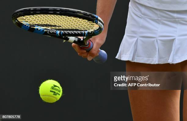 Czech Republic's Karolina Pliskova bounces a Wimbledon-braded ball before serving to Russia's Evgeniya Rodina during their women's singles first...