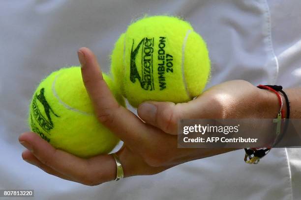 Czech Republic's Karolina Pliskova holds Wimbledon-branded Slazenger tennis balls before serving to Russia's Evgeniya Rodina during their women's...
