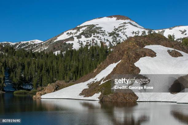 Thick layer of snow still covers the mountains above Highway 120 at Ellery Lake near Tioga Pass on June 28 near Lee Vining, California. Following a...