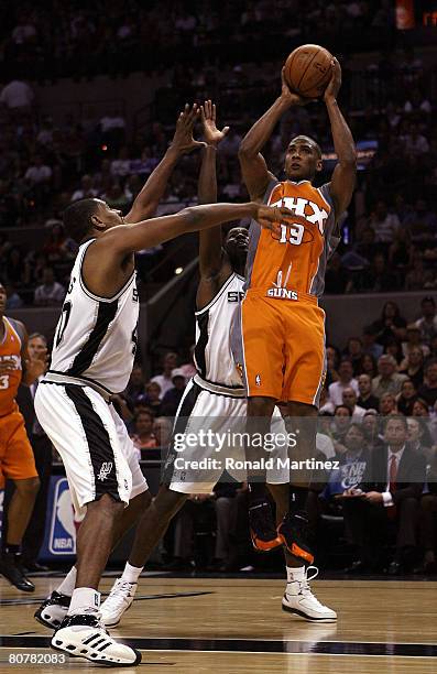 Guard Raja Bell of the Phoenix Suns takes a shot against Kurt Thomas and Michael Finley of the San Antonio Spurs in Game One of the Western...