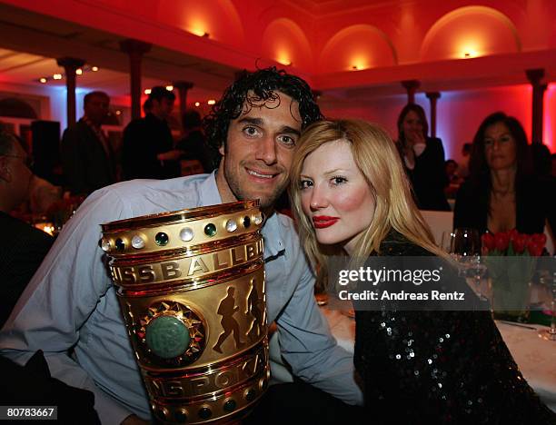 Luca Toni and girlfriend Marta Cecchetto hold the trophy at the the Bayern Munich champions party after the DFB Cup Final match between Borussia...