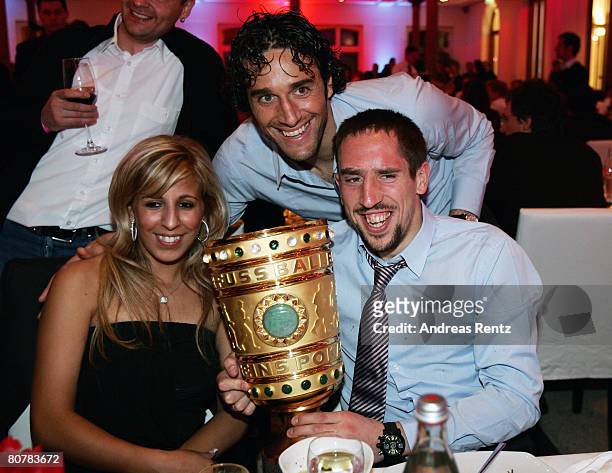 Franck Ribery and his wife Wahiba Ribery hold the trophy as Luca Toni smiles during the Bayern Munich champions party after the DFB Cup Final match...