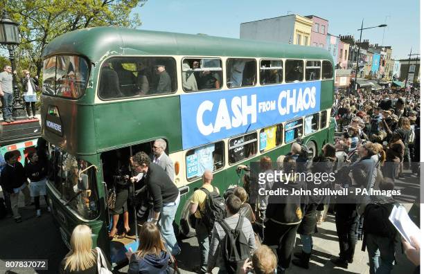 Double-decker bus carrying friends and relatives follows the horse-drawn carriage carrying the coffin of Malcolm McLaren, best known as the manager...