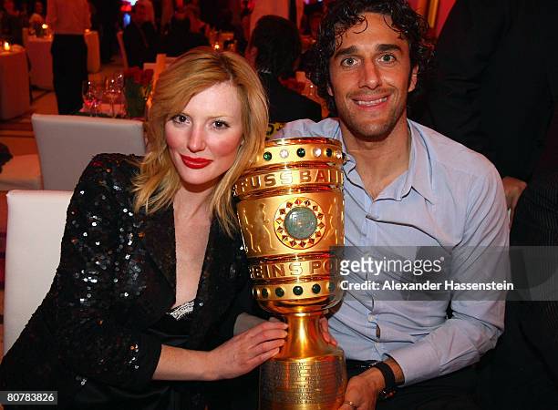 Luca Toni of Bayern Munich poses with his girlfriend Marta Cecchetto and the DFB-Trophy during the Bayern Munich champions party after the DFB Cup...