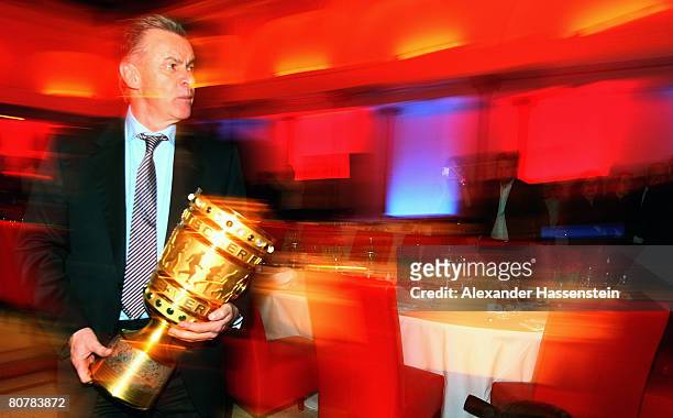 Ottmar Hitzfeld, head coach of Bayern Munich, holds the DFB-Trophy during the Bayern Munich champions party after the DFB Cup Final match between...