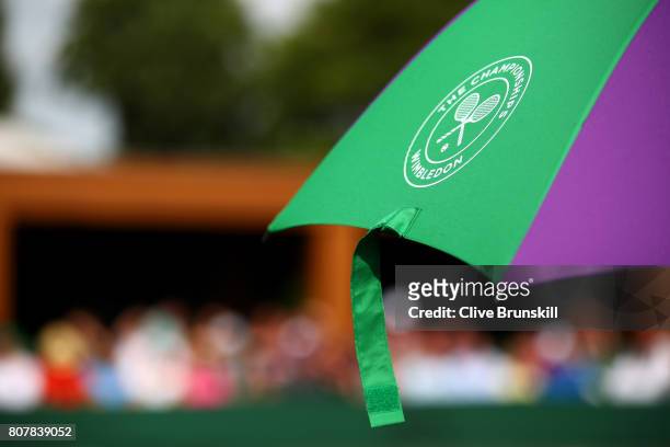 The Wimbledon logo is seen on a umbrella on day two of the Wimbledon Lawn Tennis Championships at the All England Lawn Tennis and Croquet Club on...