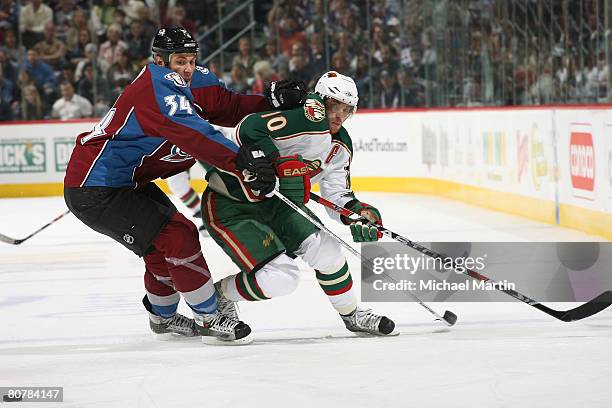 Kurt Sauer of the Colorado Avalanche fights for position with Marian Gaborik of the Minnesota Wild during game six of the Western Conference...