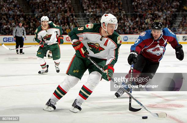 Mikko Koivu of the Minnesota Wild controls the puck as Andrew Brunette of the Colorado Avalanche defends during Game Six of the 2008 NHL Western...