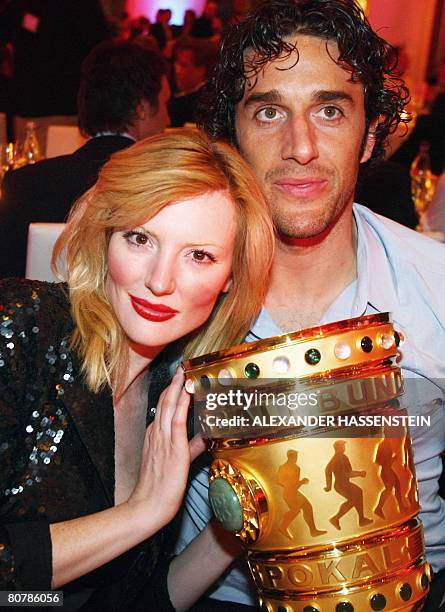 Bayern Munich's Italian striker Luca Toni poses with his girlfriend Italian model Marta Cecchetto and the German Cup trophy on early April 20, 2008...