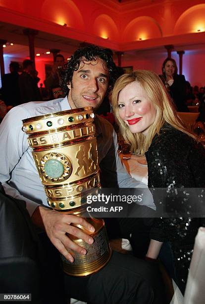 Bayern Munich's Italian striker Luca Toni poses with his girlfriend Italian model Marta Cecchetto and the German Cup trophy on early April 20, 2008...