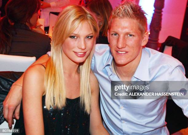 Bayern Munich's midfielder Bastian Schweinsteiger and his girlfriend Sarah Brandner pose with the German Cup trophy on early April 20, 2008 during...