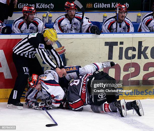 Jens Baxmann of the Eisbaeren falls over Philip Gogulla of the Haie during the DEL Play-Offs final match between Koelner Haie and Eisbaeren Berlin at...