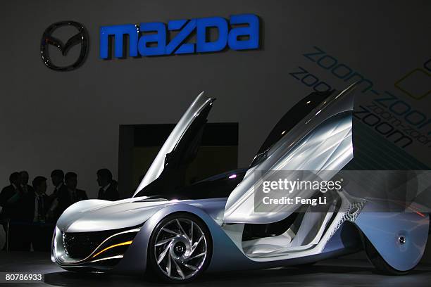 Visitors stand beside the Mazda concept car Taiki during a special media opening of the Auto China 2008 show at the new China International...