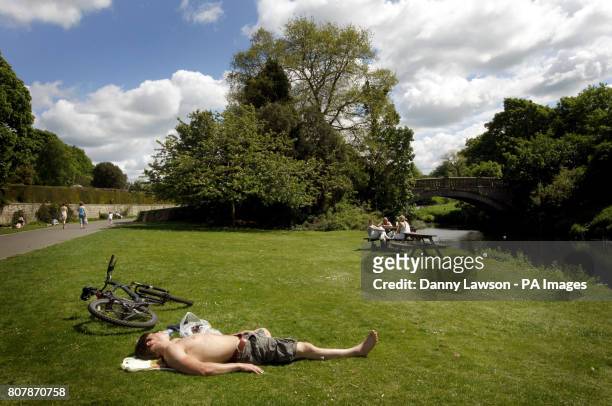 Man sunbathes in Pollok Park in Glasgow as the warm weather continues.