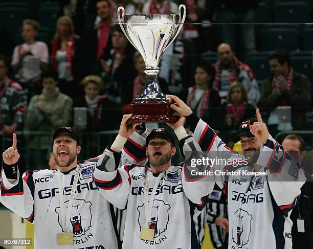 Stefan Ustorf, Steve Walker and Denis Pederson of the Eisbaeren Berlin lift the trophy after winning the DEL Play-Offs final match against Koelner...