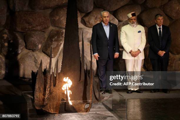 Indian Prime Minister Narendra Modi accompanied by Israeli Prime Minister Benjamin Netanyahu and Yad Vashem Chairman Avner Shalev stand during a...