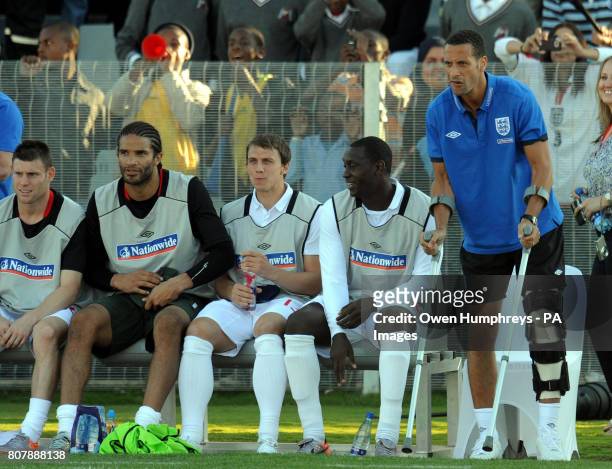 An injured Rio Ferdinand looks on alongside teammates on the touchline during the training match at Moruleng Stadium, Moruleng, South Africa.