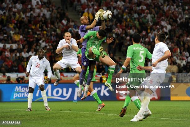Algeria goalkeeper Rais M'Bohli collects the ball under pressure from England's Wayne Rooney