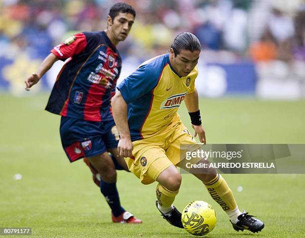 Salvador Caba?as of America vies for the ball with Edgar Trujillo of Atlante during their Mexican league football match in Mexico City, on April 20,...