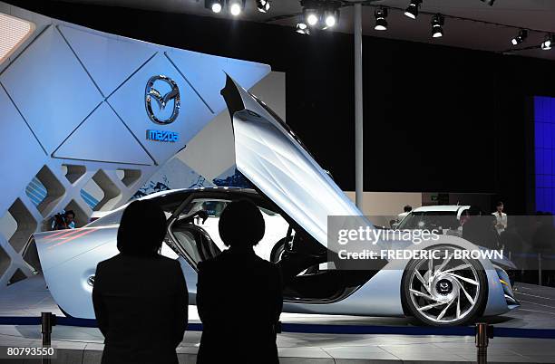 People view a display of the Taiki, a concept car by Mazda at the Beijing Auto Show on April 21, 2008. The world's top car-makers are exhibiting...