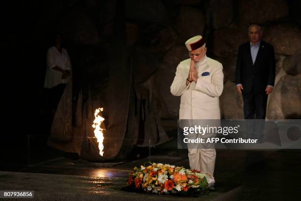 Indian Prime Minister Narendra Modi prays after laying a wreath during a memorial ceremony at the 'Hall of Remembrances' in the Yad Vashem Holocaust...