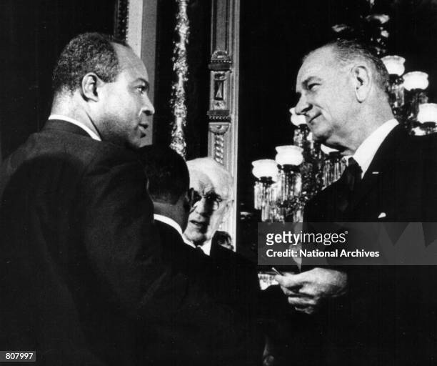 President Lyndon B Johnson presents one of the pens used to sign the Voting Rights Act of 1965 to James Farmer, Director of the Congress of Racial...