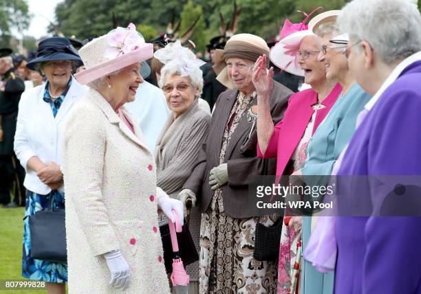 Queen Elizabeth II meets members of the Glasgow Wrens Association during the annual garden party at the Palace of Holyroodhouse on July 4, 2017 in...